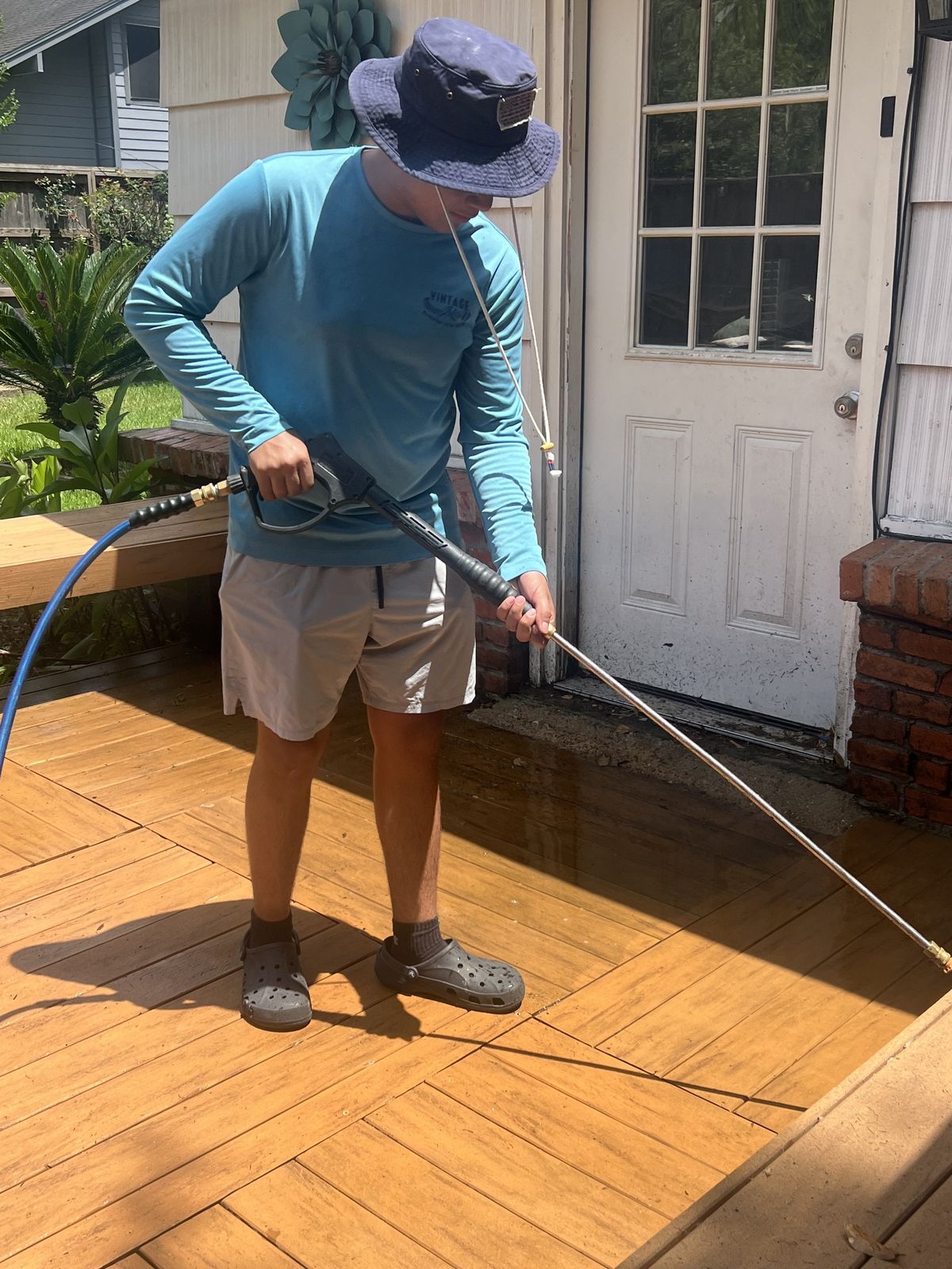 Daniel power washing a wood deck